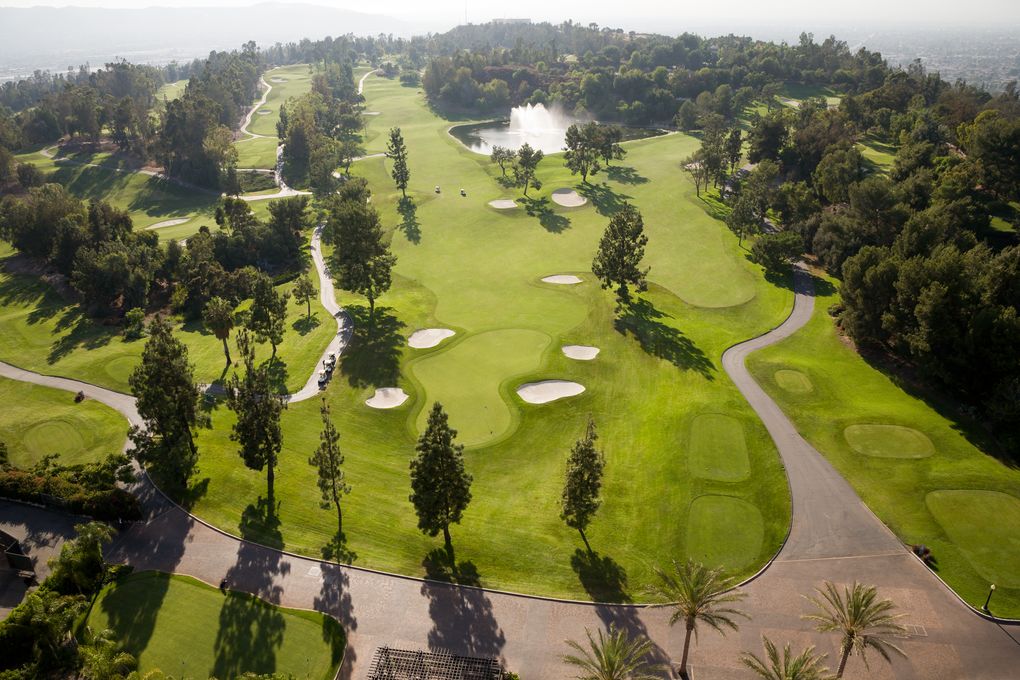 aerial view of a golf course bunkers, pathways, and water hazard