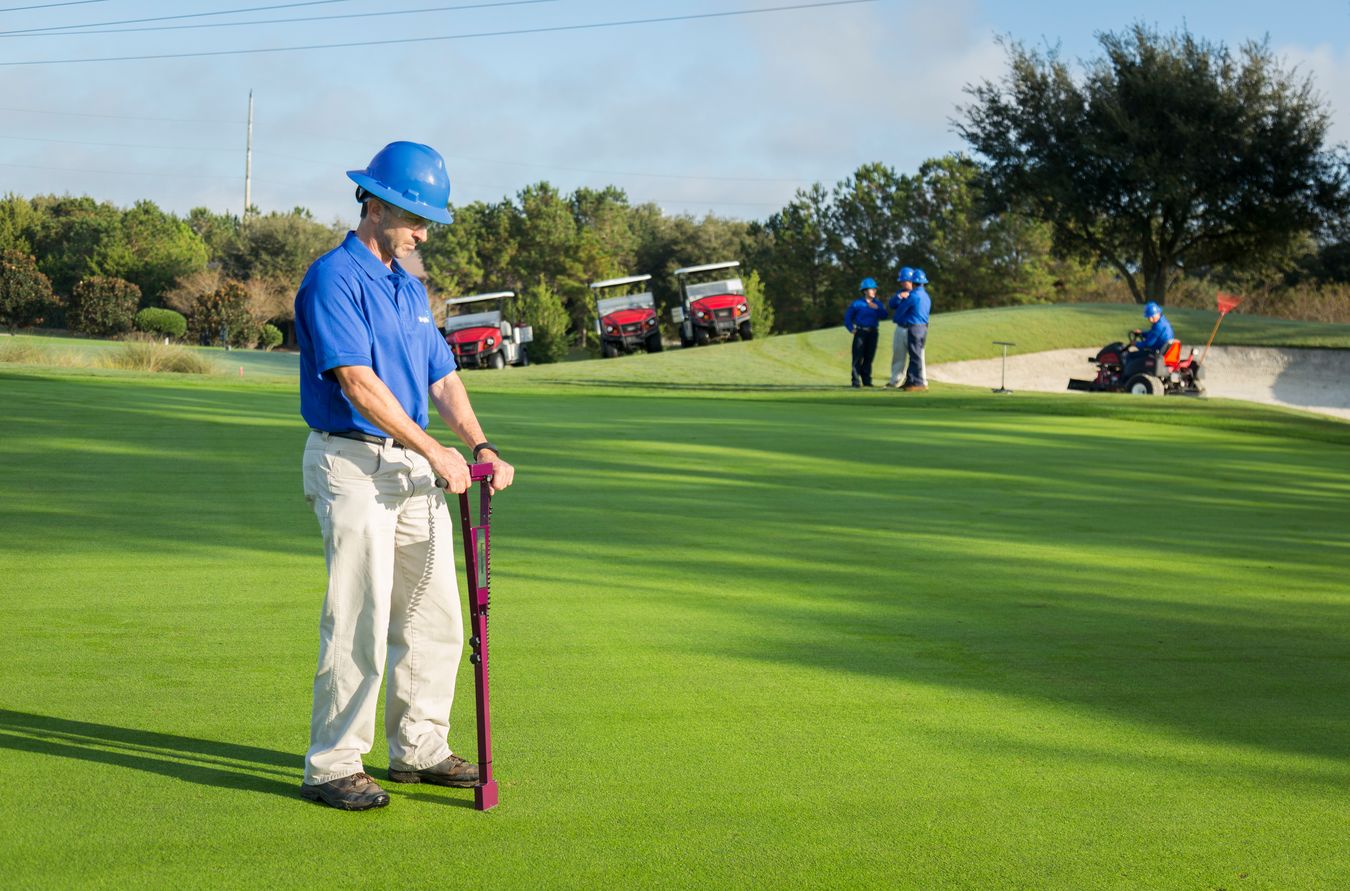 agronomist collecting a soil sample on a golf course
