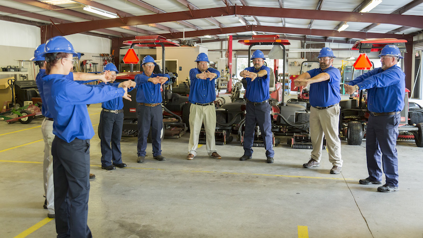 golf course maintenance crew members stretching
