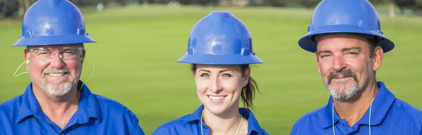 three golf course maintenance crew members